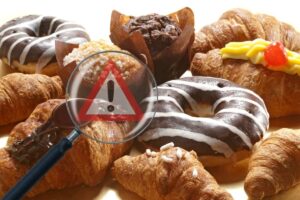 merendine con lente ingrandimento e segnale pericolo