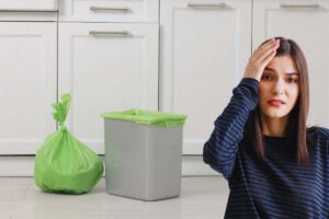 pattumiera rifiuti e donna preoccupata